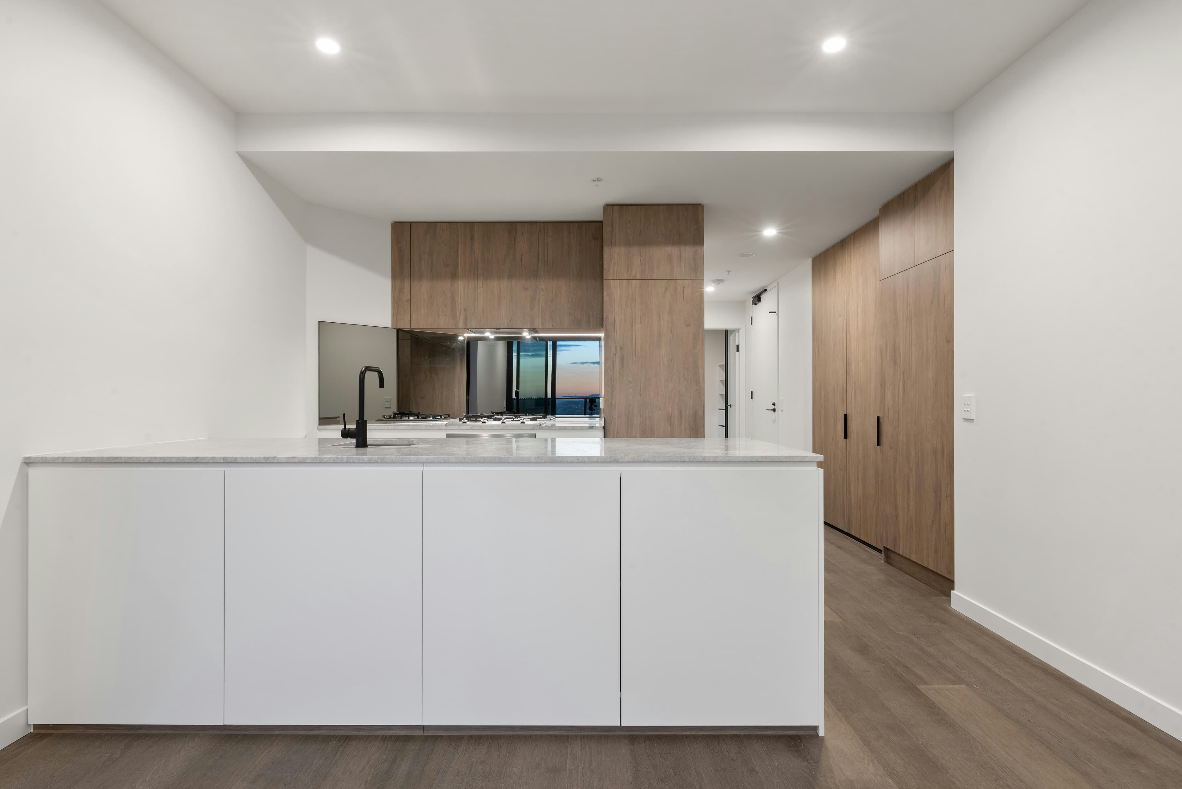 Modern Australian kitchen with white countertops and wooden cabinetry